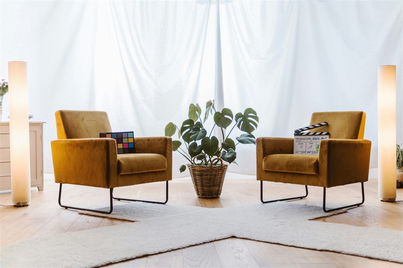 Two mustard armchairs facing each other in a bright therapy room with a plant between them