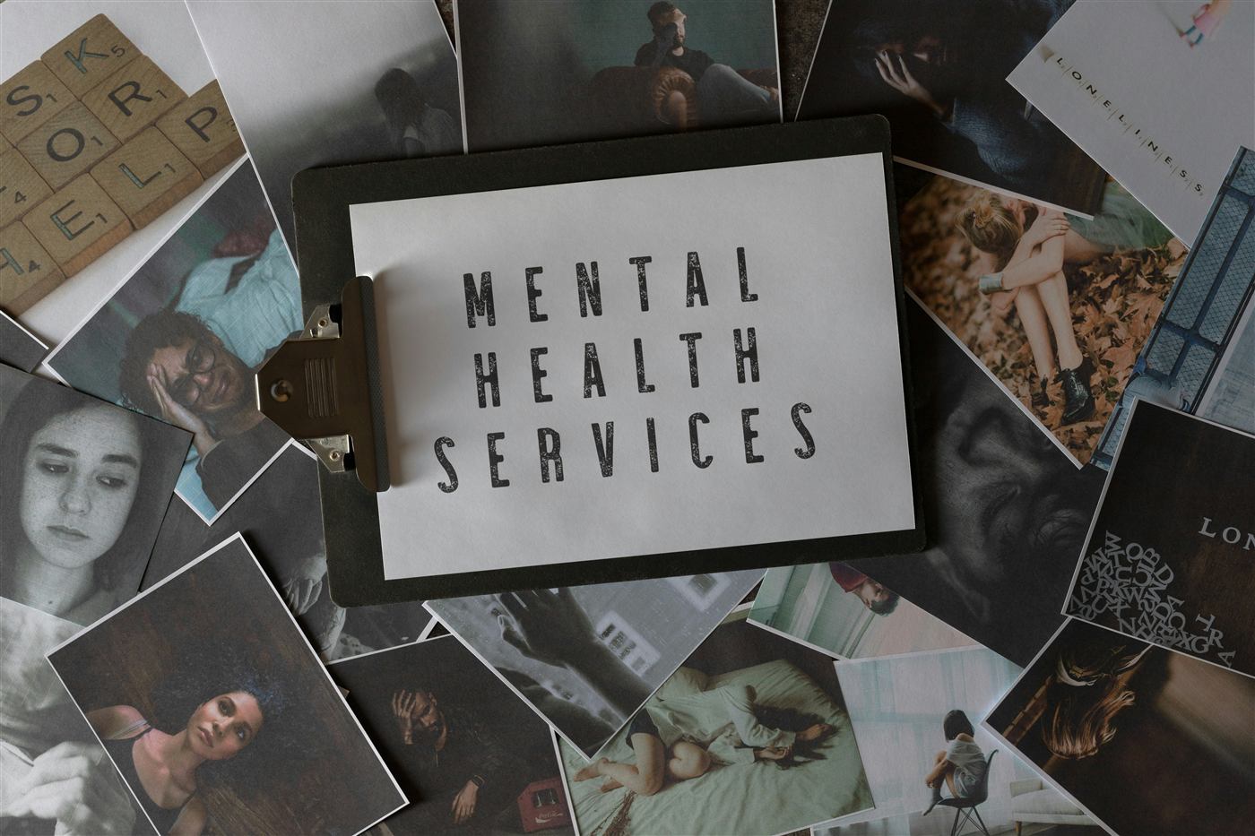 Clipboard labeled Mental Health Services surrounded by printed photos